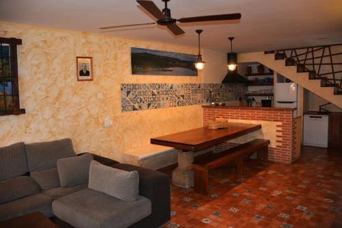 Casa Rural El Pajar de Puchero في رويديرا: غرفة معيشة مع أريكة وطاولة