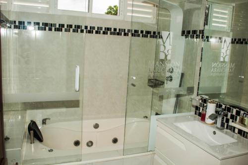 a bathroom with a shower and a tub and a sink at Hotel Mansión Barichara in Barichara