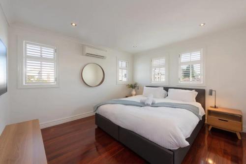 1 dormitorio con 1 cama grande y espejo en Renovated 3 Bedroom Family Home in Richmond with Parking, en Melbourne
