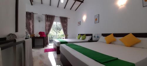 a bedroom with two beds and a living room at Senomaal Sigiri Resort in Dambulla