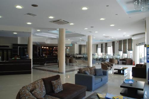 a lobby with couches and chairs in a building at Letsos Hotel in Alykes