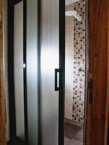 a bathroom with a door to a shower with a shower at Zendo Suite in Nairobi