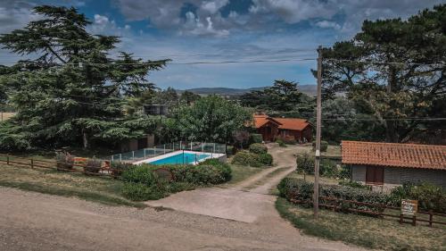 a home with a swimming pool and a house at Cabañas del Golf in Sierra de la Ventana