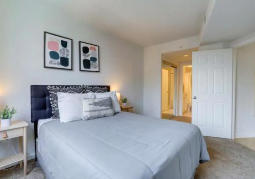 a bedroom with a large white bed and a door at Fantastic 1BD Condo At Ballston With Gym in Arlington