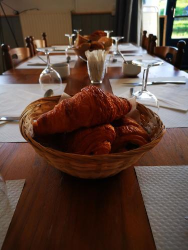 a basket of bread sitting on a wooden table at Les chambres du Bistro du Canal in Pleyben