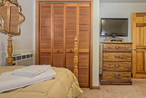 a bedroom with a bed and a tv and a dresser at Hannahs Perch on Lake Burton with Private Top Patio and Bottom Dock in Clayton