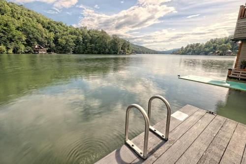 a dock with two metal chairs on a lake at Hannahs Perch on Lake Burton with Private Top Patio and Bottom Dock in Clayton