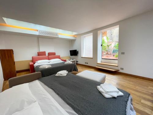 Pokój z 2 łóżkami, kanapą i oknem w obiekcie La Pigna Boutique Apartment w Rzymie