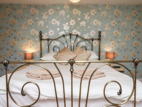 a bedroom with a bed with flowers on the wall at Apple Blossom in Newton Abbot