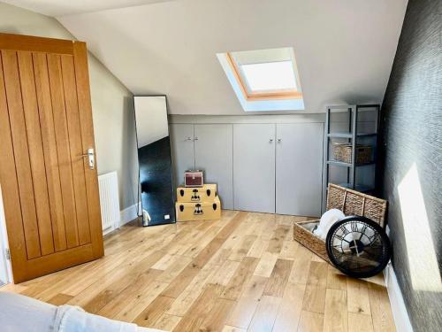 a living room with a skylight and a wooden floor at Lovely two bed flat in London