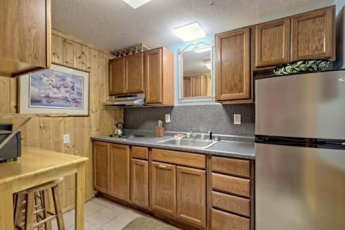 a kitchen with wooden cabinets and a stainless steel refrigerator at Bills Bungalow on Lake Burton with Top Dock and Patio in Clayton