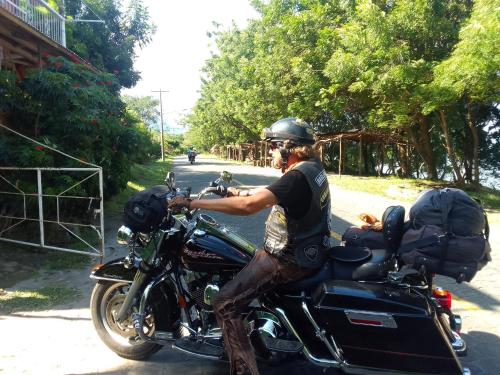 a man sitting on a motorcycle on the road at Beach cabin ometepe in Altagracia