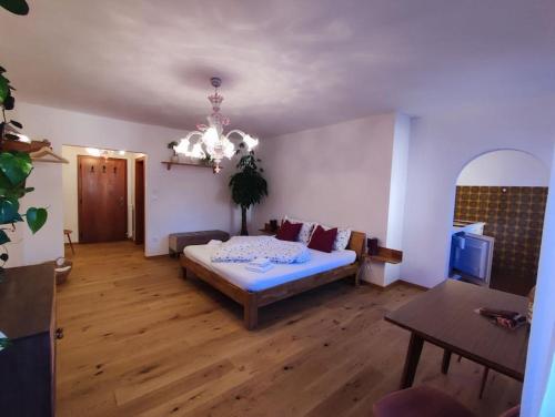 sala de estar con cama y lámpara de araña en Gemütliches Studio mit Garagenparkplatz en Vols am Schlern