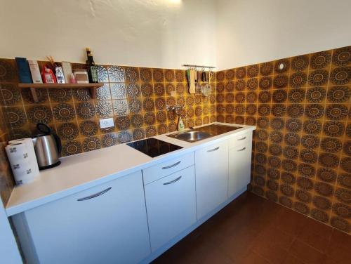 een keuken met een wit aanrecht en een wastafel bij Gemütliches Studio mit Garagenparkplatz in Vols am Schlern