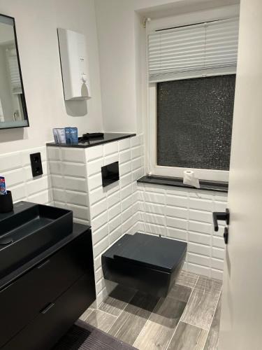 Łazienka z czarną toaletą i umywalką w obiekcie Haus Gabor w mieście Mülheim an der Ruhr