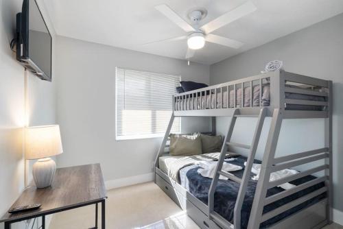 Un dormitorio con una litera y un escritorio. en Roxanas 3bed 2bath Home with Modern Interior and BBQ Backyard, en Fort Lauderdale
