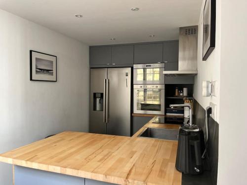 a kitchen with a wooden counter top with a refrigerator at Atelier 84 - AC - Loft - Avignon Centre Ville in Avignon
