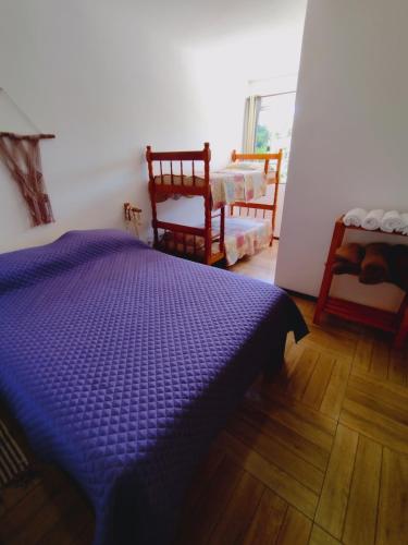 a bedroom with a purple bed and two chairs at Saquaflats in Saquarema
