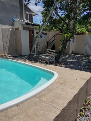 a swimming pool in a yard next to a house at Saquaflats in Saquarema
