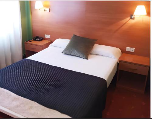 a bedroom with a large bed with a pillow on it at Hotel San Millán in Santander