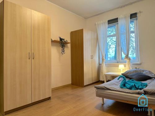 a bedroom with a bed and a cabinet and a window at Beige Room in Gdańsk