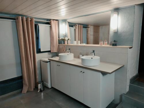 een badkamer met 2 wastafels en 2 spiegels bij La maison d'Amélie in Sommerau
