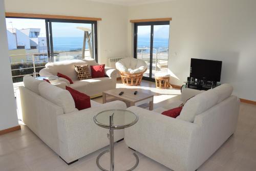 a living room with two white couches and a television at Vila Oceânica 2 in Buarcos