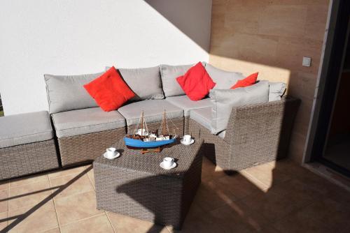 a living room with a couch and a table with red pillows at Vila Oceânica 2 in Buarcos