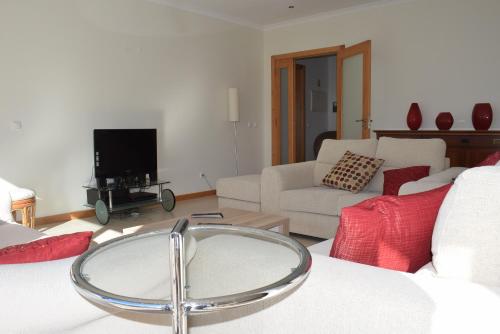 a living room with a couch and a tv at Vila Oceânica 2 in Buarcos