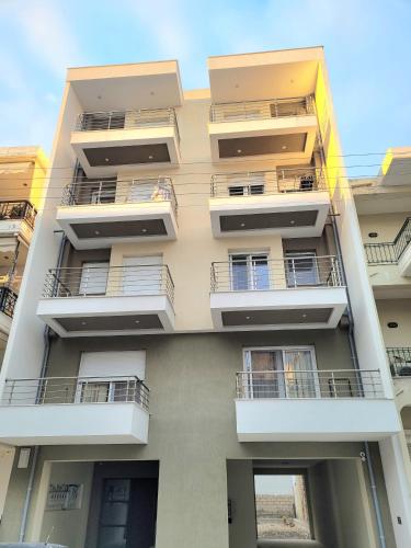 a tall white building with balconies on it at 8 Blocks Apartments in Alexandroupoli