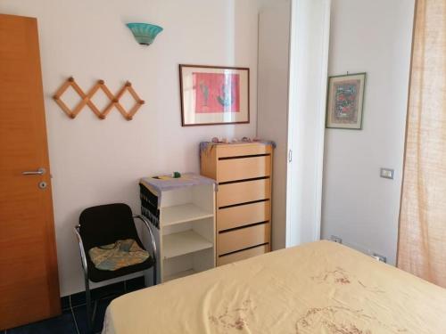 um quarto com uma cama, uma secretária e uma cadeira em Grazioso appartamento a Ischia zona pilastri em Ischia
