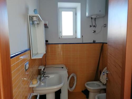 uma pequena casa de banho com lavatório e WC em Grazioso appartamento a Ischia zona pilastri em Ischia