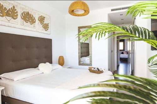 une chambre avec un lit blanc et une plante dans l'établissement Sunset waves Benidorm 136, à Benidorm
