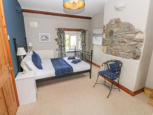 a bedroom with a bed and a chair at 2 Yr Hen Felin in Haverfordwest
