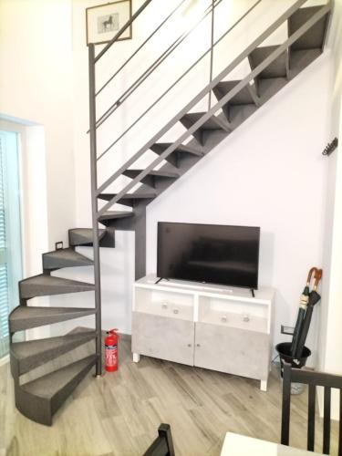 a living room with a staircase and a tv at L'appartamento di Rita in Nettuno