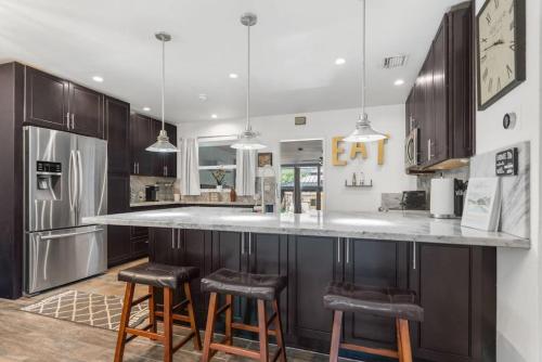 a kitchen with a large counter with stools at Wileys Paradise Three Bedroom Two Bath plus Office and Heated Pool in Hollywood