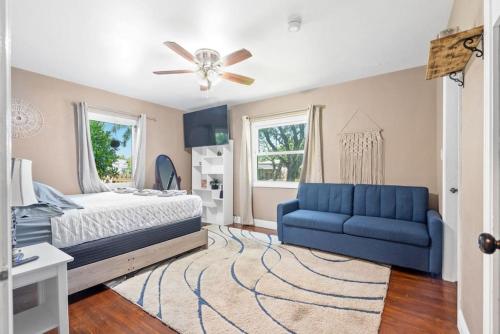 Un dormitorio con una cama y un sofá azul. en Wileys Paradise Three Bedroom Two Bath plus Office and Heated Pool, en Hollywood