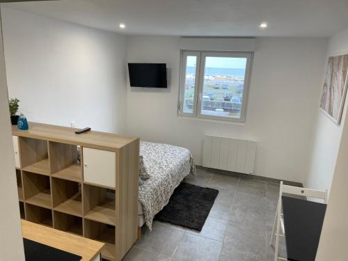 ein kleines Schlafzimmer mit einem Bett und einem Fenster in der Unterkunft Studio vue sur mer classé 3 étoiles, Calais in Calais