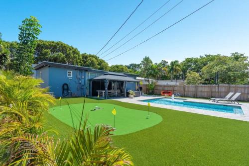 a backyard with a putting green and a pool at Wileys Paradise Three Bedroom Two Bath plus Office and Heated Pool in Hollywood