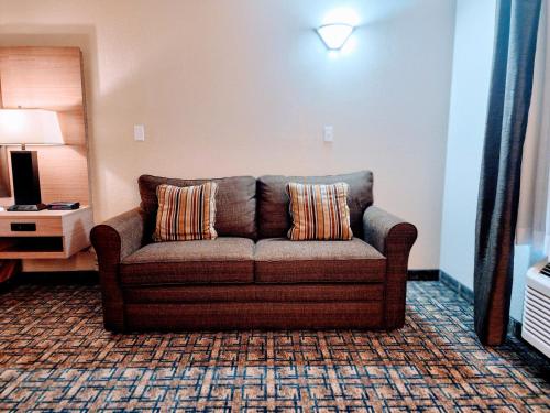 a living room with a couch in a hotel room at Gold Circle Inn in Lloydminster