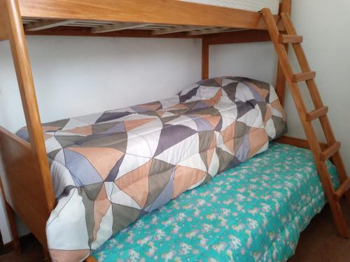 a bedroom with a bunk bed with a bench underneath it at La Casita de Lu in San Carlos de Bariloche