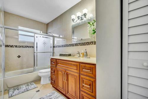 ein Bad mit einem Waschbecken, einem WC und einer Dusche in der Unterkunft Three Bedroom Pool Home with Modern Interior Design in Coral Springs