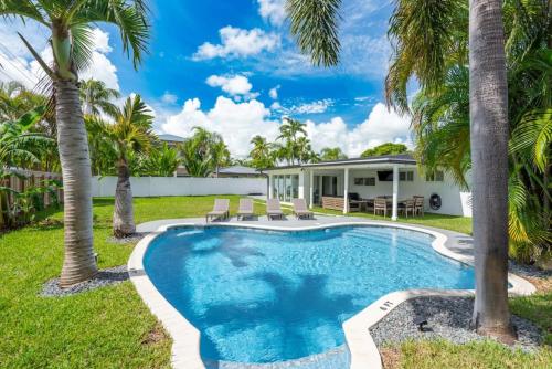 uma piscina em frente a uma casa com palmeiras em Delilas Chic 3 Bedroom 2 bath Abode with Heated Pool em Deerfield Beach