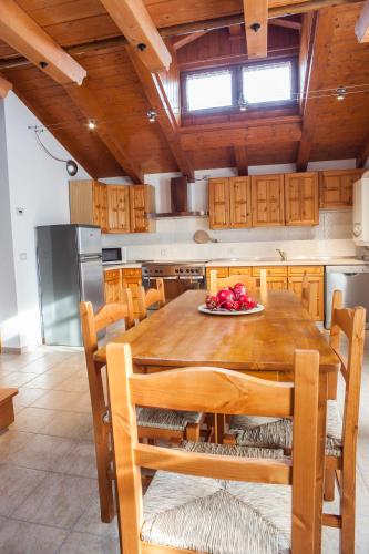 a large kitchen with a wooden table and chairs at Albergo Diffuso Dolomiti in Forni di Sotto