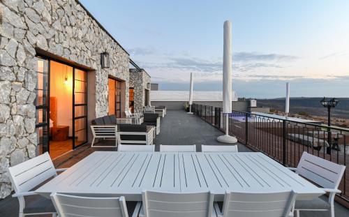 a white table and chairs on a balcony at הודולה - וילות נדירות עם ממ"ד ובריכות פרטיות ונוף מושלם לכנרת in Giv'at Yo'av