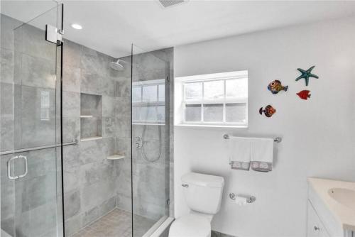 フォート・ローダーデールにあるChic Victoria Park Villa with Heated Pool and Spaのバスルーム(ガラス張りのシャワー、トイレ付)