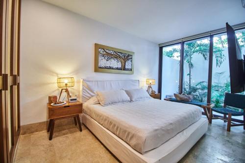 um quarto com uma cama e uma grande janela em Omara 2-BR Pool · Tropical 2-BR Condo With Private Pool + Amenities! em Tulum