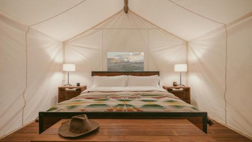 um quarto com uma cama com um chapéu de cowboy em ULUM Moab em La Sal