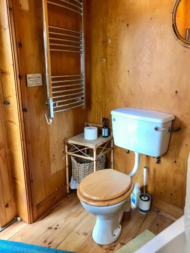 a bathroom with a toilet with a wooden floor at Bijou Cottage in Brontë Country with Wood-burning Stove & Hot Tub Spa in Haworth