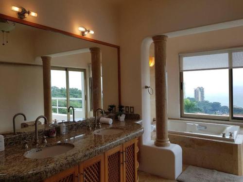 a bathroom with two sinks and a large mirror at Villa Mozzafiato Private Resort with Full Staff and Heated Pool in Puerto Vallarta